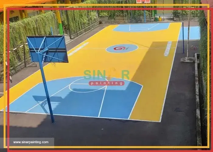 jasa pengecatan lapangan basket sekolah warna biru kuning garis putih dengan logo di tengah